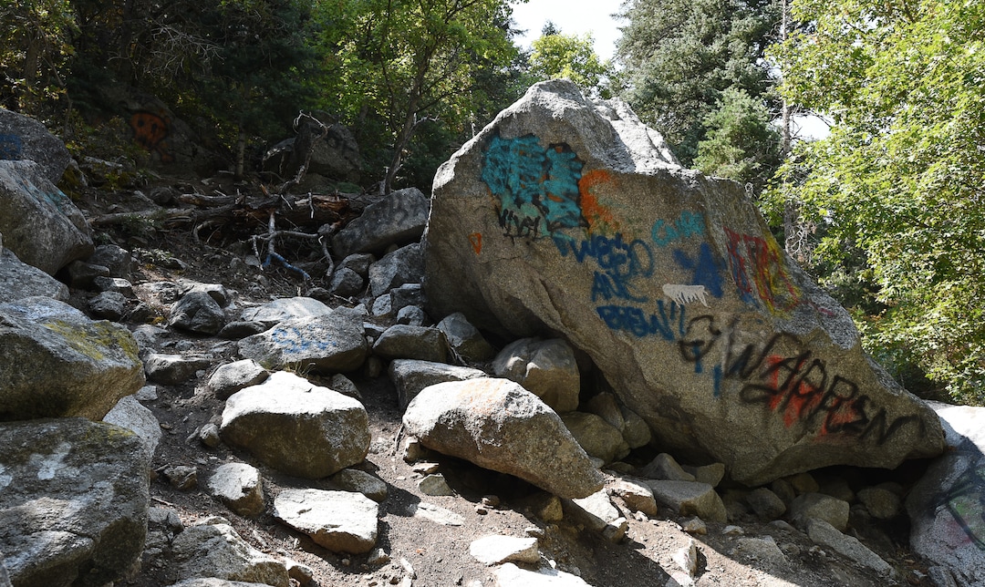 (Francisco Kjolseth  |  The Salt Lake Tribune)  Graffiti has proliferated in lower Little Cottonwood Canyon, where vandals, often wielding cans of fluorescent-colored spray paint, have covered granite faces, trees and structures. The vandalism is particularly apparent along the Temple Quarry Trail and the creek at the Moon Rock swimming hole and former pavilion site. Volunteers using donated equipment and solvents spend thousands of hours removing the paint from the rocks only to see graffiti return to the same faces or on rock nearby.