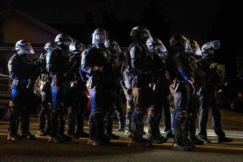 (Paula Bronstein | The Associated Press) Portland police take control of the streets after making arrests on the scene of the nightly protests at a Portland police precinct on Sunday, Aug. 30, 2020 in Portland, Ore. Oregon State Police will return to Portland to help local authorities after the fatal shooting of a man following clashes between President Donald Trump supporters and counter-protesters that led to an argument between the president and the city's mayor over who was to blame for the violence.