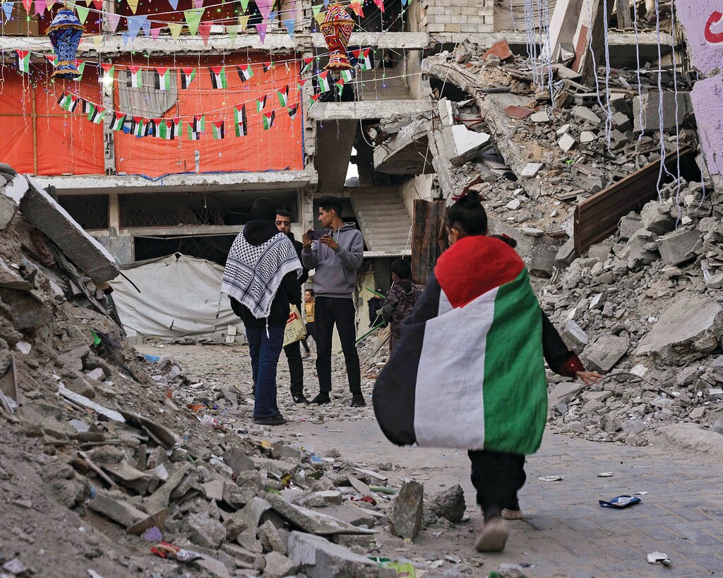 Palestinians hang decorations next to their destroyed homes in preparation for the holy month of Ramadan in Khan Yunis, southern Gaza Strip, on Feb. 28, 2025. (Saher Alghorra/The New York Times)