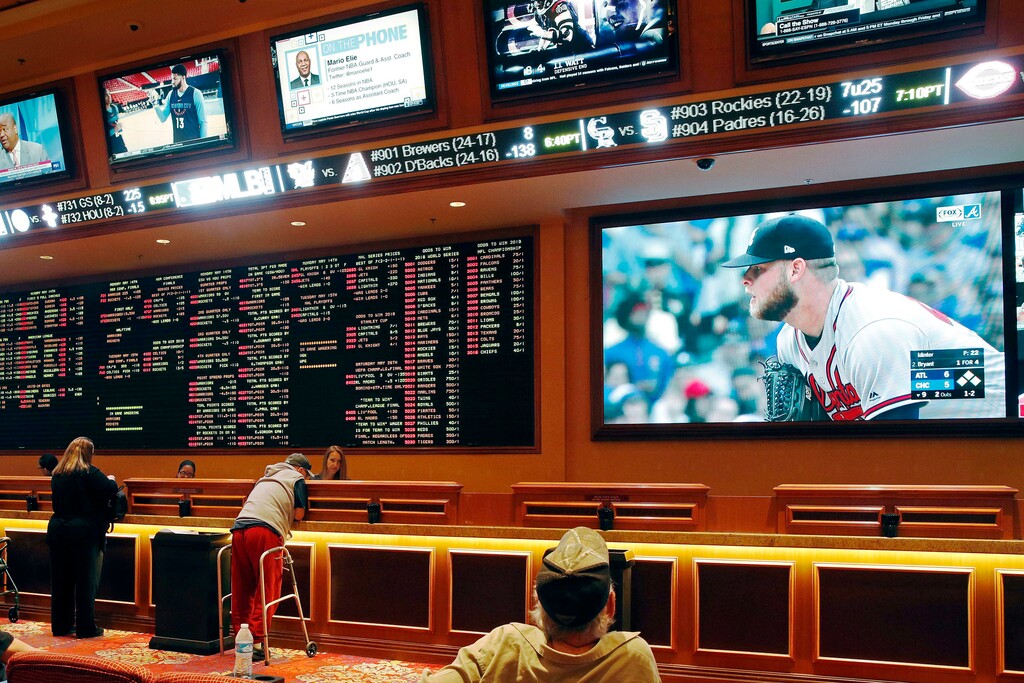 FILE - In this Monday, May 14, 2018 file photo, people make bets in the sports book area of the South Point Hotel and Casino in Las Vegas. Those who deal with compulsive gambling are worried that a rapid expansion of sports betting in the U.S. could cause more people to develop gambling problems. The U.S. Supreme Court on Monday cleared the way for states to legalize sports betting. (AP Photo/John Locher, File)