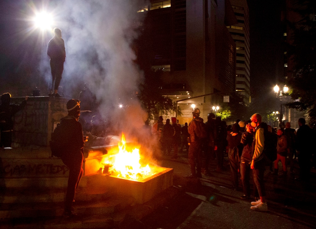 Twice on July Fourth, police declared a riot in downtown Portland, Ore., July 4, 2020. Portland police say more than 12 people were arrested early Sunday after throwing fireworks and mortars as they clashed with police during the latest rally decrying police brutality. (Beth Nakamura/The Oregonian via AP)