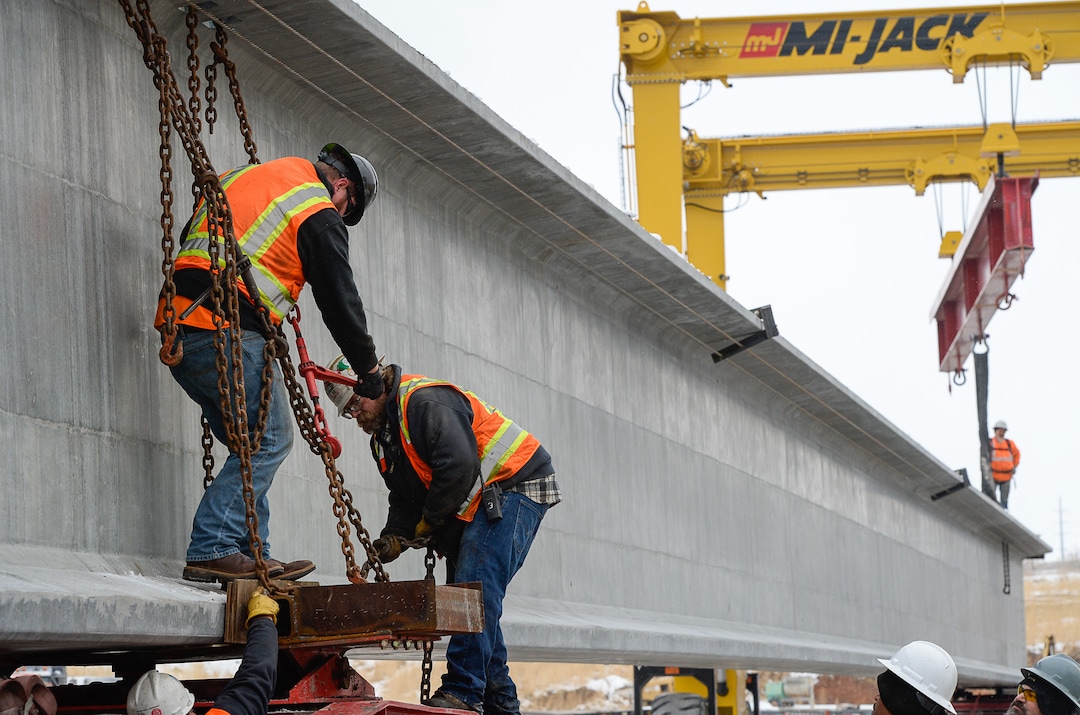 (Francisco Kjolseth  |  The Salt Lake Tribune)  UDOT gets ready to place some of the world's largest-ever bridge beams, and the largest in Utah state history with a span of 203 ft long and just over 8 ft tall, as crews load one on a truck following manufacturing at Forterra Structural Precast in Kearns on Tuesday, Dec. 11, 2018. A total of six beams will be installed in the technology corridor in Lehi later this week.