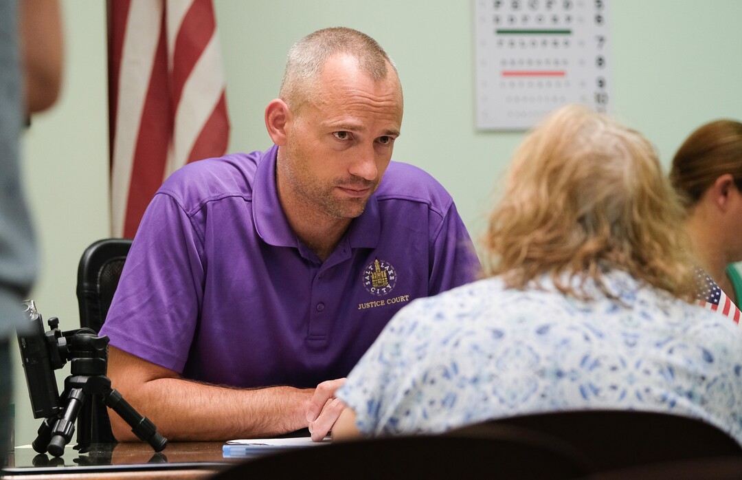 (Francisco Kjolseth  |  The Salt Lake Tribune)  Judge Clemens Laundau listens to a defendant during court held for homeless or transient people in the Weigand Center in Salt Lake City, June 28, 2019. Since May 2004, Salt Lake City has operated a homeless court, where transients can handle misdemeanor charges without showing up in regular court. This helps the homeless person by clearing outstanding warrants they have in a less intimidating environment and it also benefits the regular court by reducing its backlog of such cases. It's part of a larger effort on the part of the American Bar Association to decriminalize homelessness.