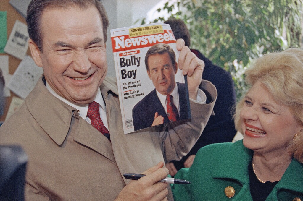 Republican presidential hopeful Patrick Buchanan, accompanied by his wife Shelley, smiles while holding a Newsweek cover of himself in 1992. (AP Photo/Karl Leitz)