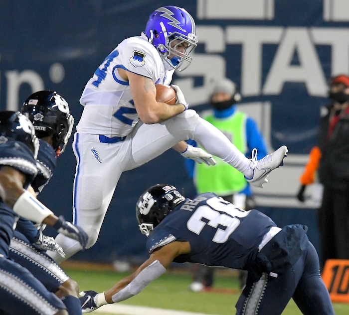 Air Force running back Kadin Remsberg (24) leaps over Utah State safety Jared Reed (36) during the second half of an NCAA college football game Thursday, Dec. 3, 2020, in Logan, Utah. (Eli Lucero/The Herald Journal via AP, Pool)