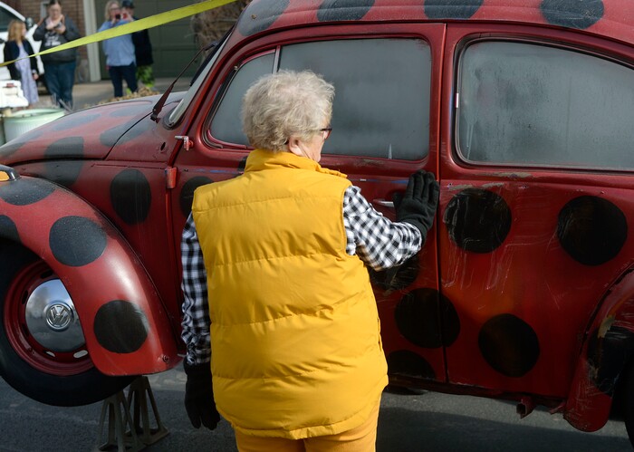 (Al Hartmann | The Salt Lake Tribune)
Clearfield public works personnel used a crane to remove Janis Zettel's gutted VW Beetle from a tree in her front yard Tuesday Feb. 13. She put it up a few months ago as an art installation. Zettel pats the old car when it's safely on the ground.