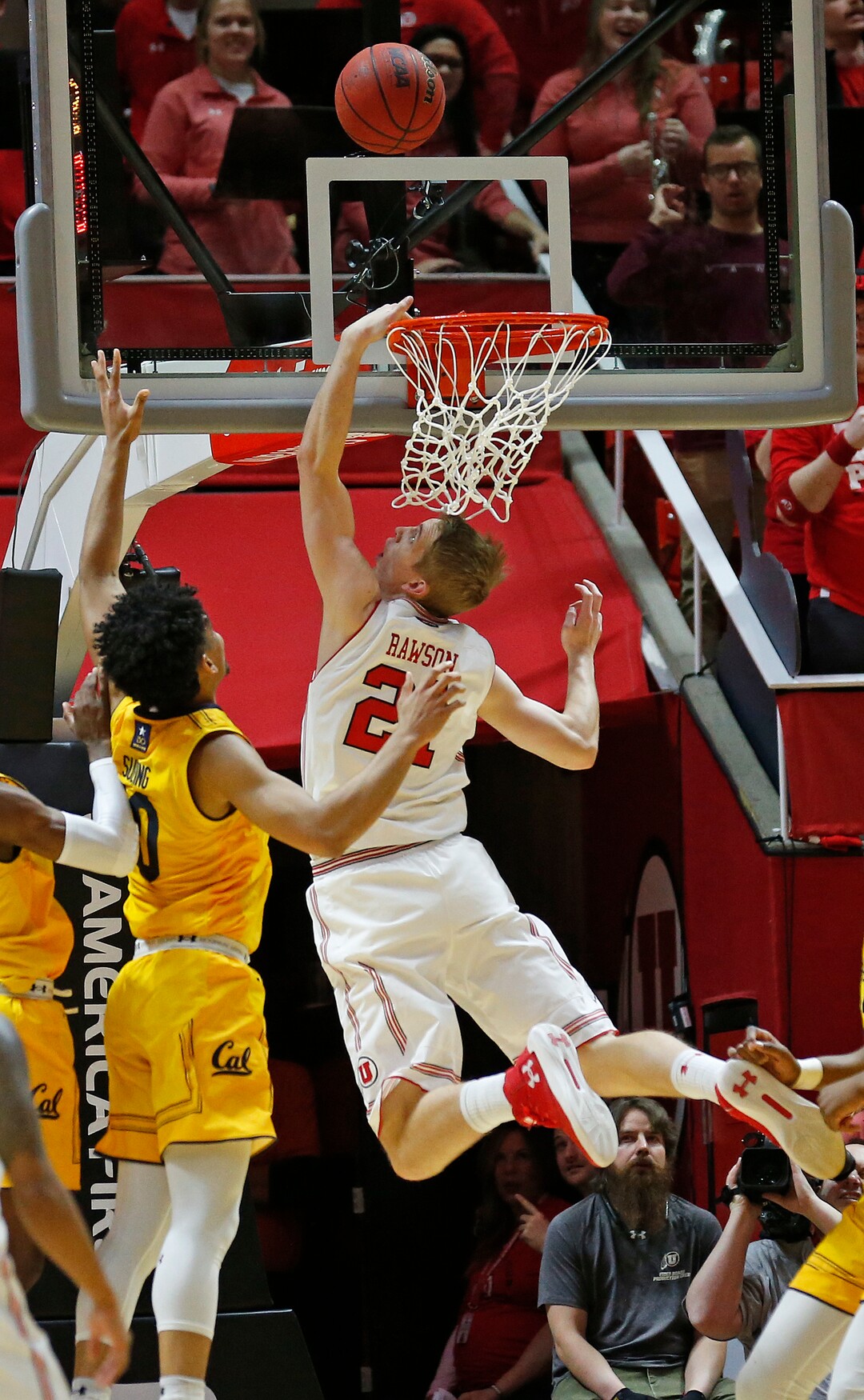 Utah forward Tyler Rawson (21) lays the ball up as California forward Justice Sueing, left, defends during the first half of an NCAA college basketball game Saturday, Feb. 10, 2018, in Salt Lake City. (AP Photo/Rick Bowmer)