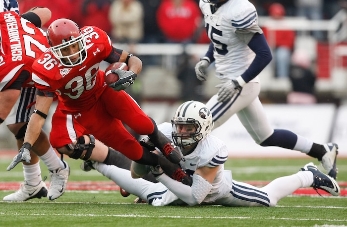 (Chris Detrick  |  Tribune file photo)  Utah Utes running back Eddie Wide #36 gets tripped up by BYU defensive back Andrew Rich (22) as the Utes face BYU in the third quarter at Rice-Eccles Stadium Saturday, November 27, 2010.