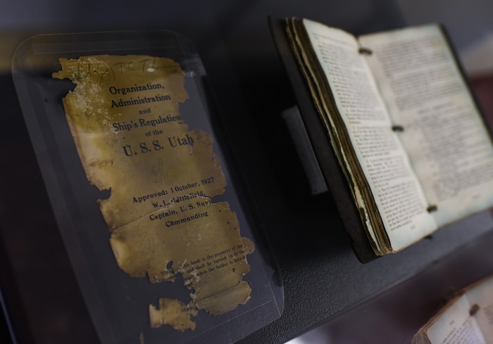 (Francisco Kjolseth  |  The Salt Lake Tribune)  A USS Utah ship's regulation book, salvaged from the captain's safe, reveals the damage sustained when the ship was lost during the attack on Pearl Harbor in 1941. The bell from the ship along with a few recovered artifacts are now on display in the Naval Science building at the University of Utah.