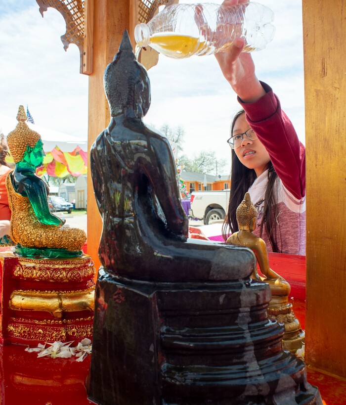 (Rick Egan  |  The Salt Lake Tribune)    Menna Tren pours holy water over the Buddha, at the Wat Lao Salt Lake Buddharam Utah, New Year Celebration, in West Valley City, Sunday, April 28, 2019.


