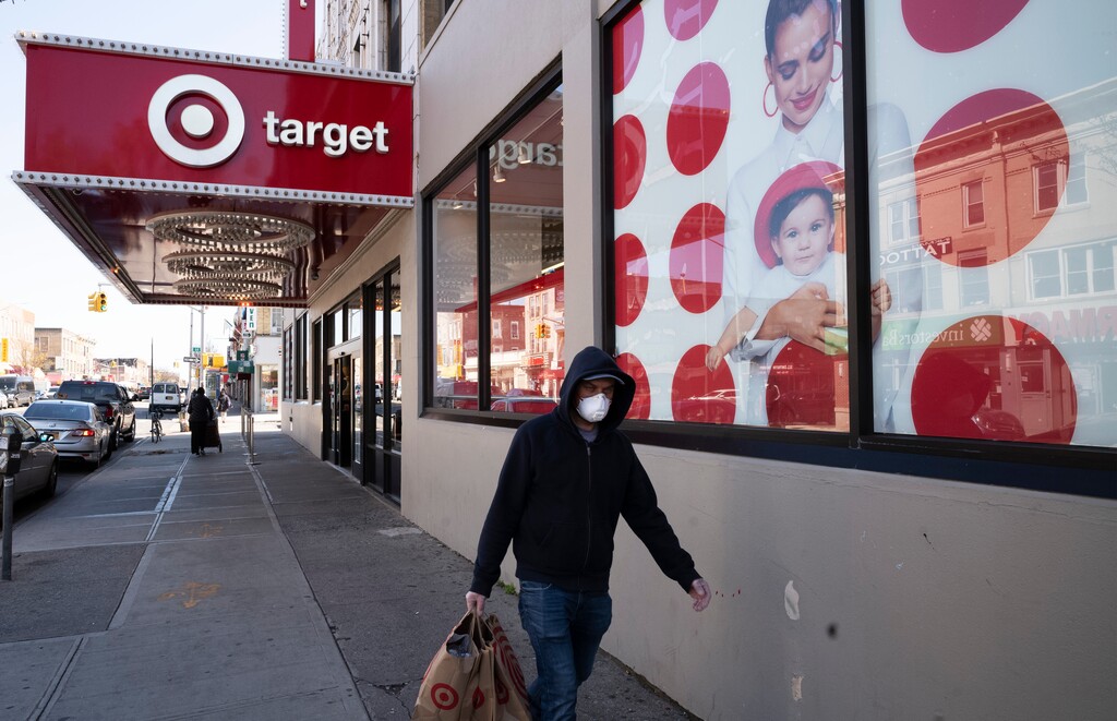 (Mark Lennihan | AP file photo) In this April 6, 2020 photo, a customer wearing a mask carries his purchases as he leaves a Target store during the coronavirus pandemic in the Brooklyn borough of New York. Target has joined a growing list of major retailers that will require customers at all their stores to wear face coverings.