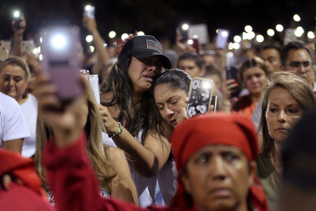 (Mark Lambie | The El Paso Times via AP) People grieve during the Hope Border Institute prayer vigil Sunday, Aug. 4, 2019 in El Paso, Texas, a day after a mass shooting at a Walmart store. Two more people died Monday, bringing the death toll to 22.