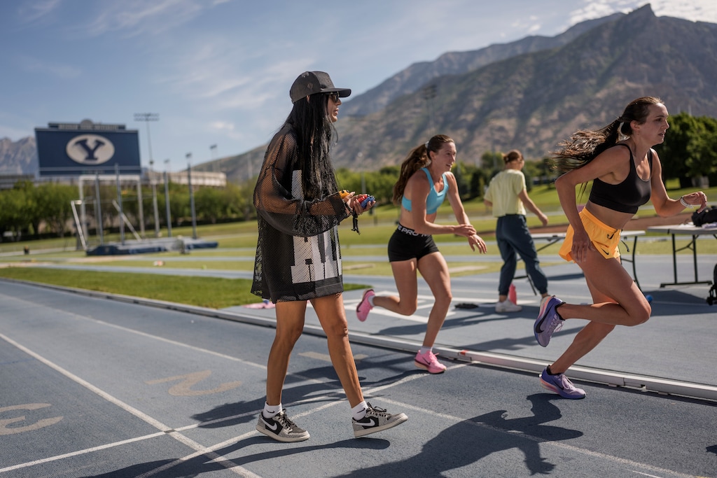 (Spenser Heaps | The New York Times) Running coach Diljeet Dosanjh Taylor works with athletes at the Brigham Young University track and field complex in Provo, Utah, June 2, 2026. Coach Taylor is known for her pep talks. “Knowing that she believed in me was enough for me to give it everything I had,” one of her runners said.