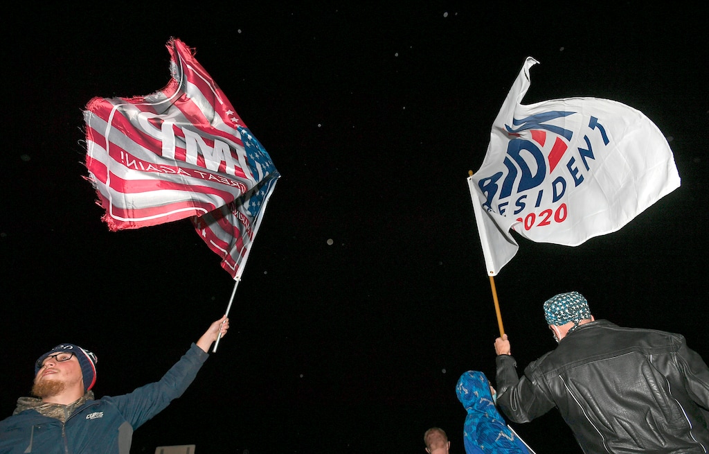 (Christopher Millette | Erie Times-News via AP)

On West 12th Street across from the Erie International Airport, Steven Lantz-Gordon, 24, at left, of Harborcreek Township, waves a flag in support of President Donald Trump near David Oberg, 60, at right, of Grand Valley, who raises a flag in support of Democratic presidential candidate and former Vice President Joe Biden during a rally held by Trump, Tuesday, Oct. 20, 2020, at Erie International Airport, Tuesday, Oct. 20, 2020, in Millcreek Township, Pa.