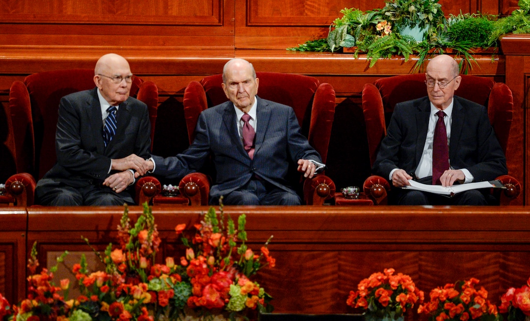 (Leah Hogsten  |  The Salt Lake Tribune) l-r President Russell M. Nelson reaches out to squeeze the hand of President Dallin H. Oaks during the morning session of the189th Annual General Conference of The Church of Jesus Christ of Latter-day Saints in Salt Lake City. President Henry B. Eyring is at right.