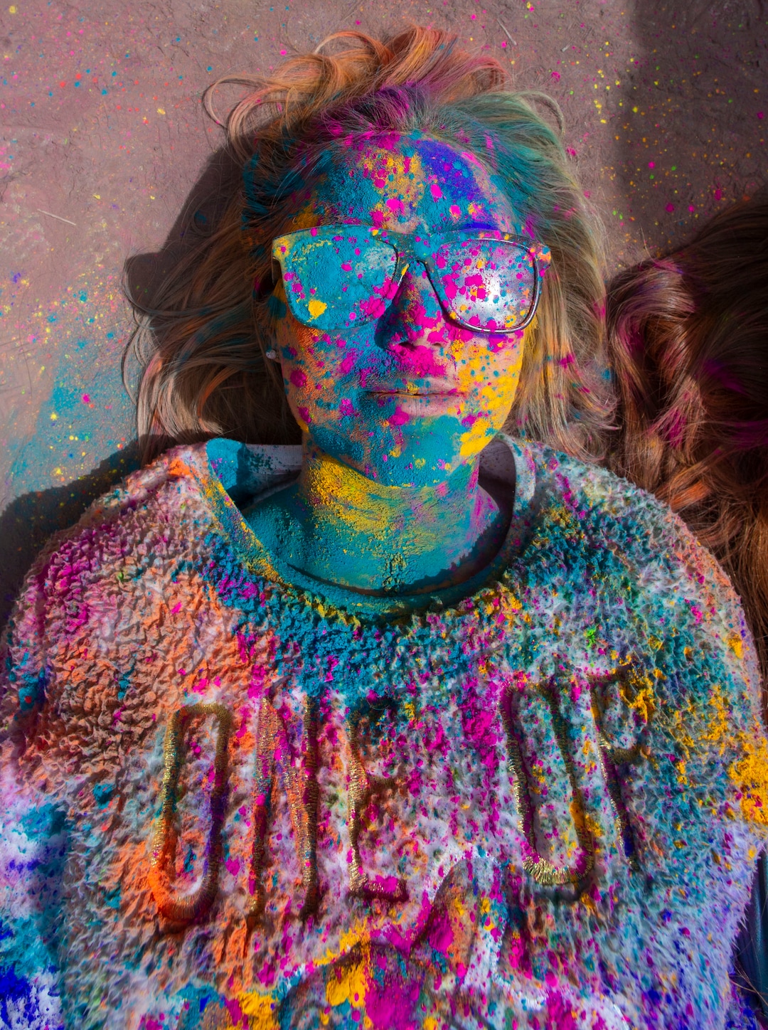 (Rick Egan  |  The Salt Lake Tribune)    Kimberly Woolsey, from Gilbert , Arizona, takes a break from the crowd and lies not the ground, during the Holi Festival of Colors celebration at the Sri Sri Radha Krishna Temple in Spanish Fork, Saturday, March 30, 2019. 