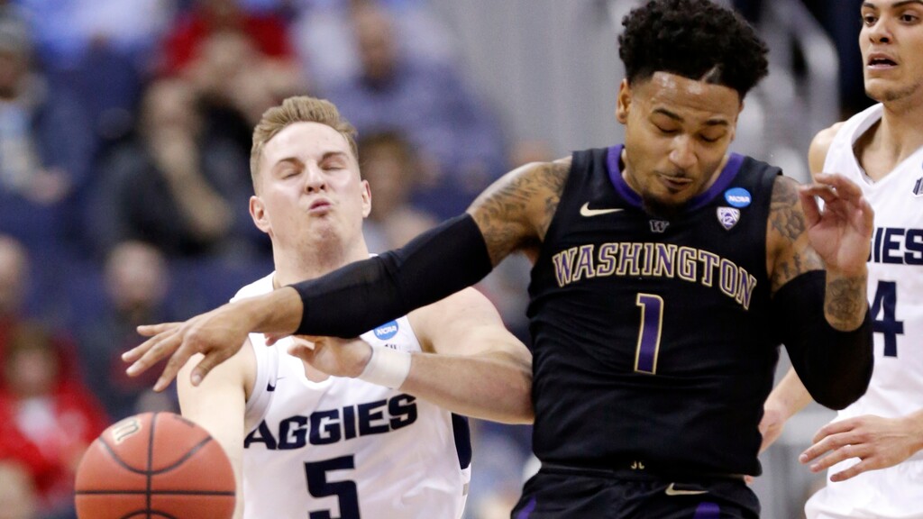 Washington's David Crisp (1) and Utah State's Sam Merrill (5) battle for the ball in the first half during a first round men's college basketball game in the NCAA Tournament in Columbus, Ohio, Friday, March 22, 2019. (AP Photo/Paul Vernon)