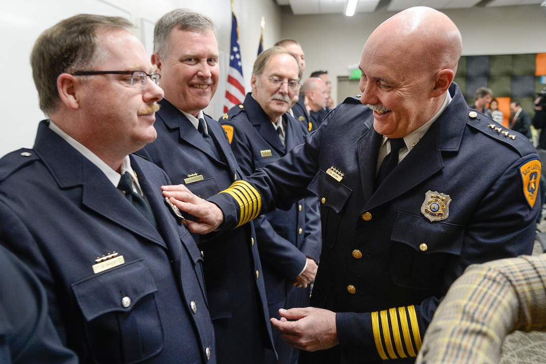 (Francisco Kjolseth  |  The Salt Lake Tribune)  Salt Lake City Police Chief Mike Brown presents Sgt. Brent Baker of the airport police department with a new badge during a ceremony to retire their old patch and badge as they are subsumed into the Salt Lake City Police Department on Tuesday, Feb. 26, 2019. 