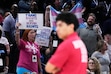 (Nam Y. Huh | AP) Fans stand up as they hold signs while Chicago Sky guard Natasha Cloud argues with former NBA center Enes Kanter Freedom during the second half of a WNBA basketball game against the Indiana Fever, Sunday, Aug. 23, 2026, in Chicago.