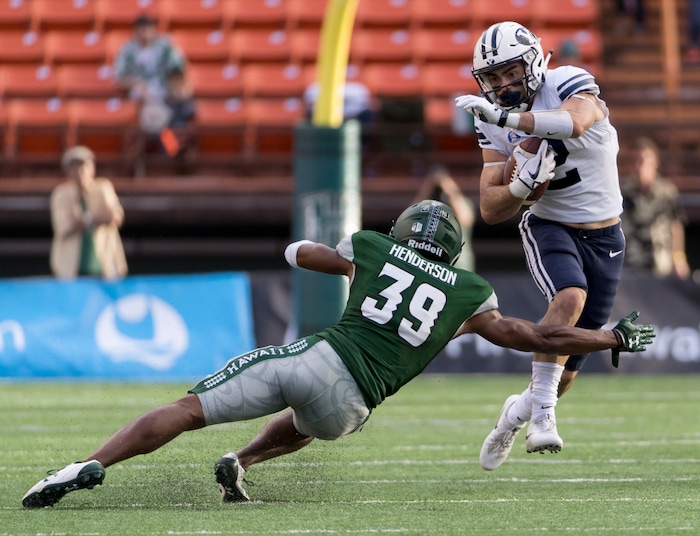 BYU running back Austin Kafentzis (2) attempts to get by Hawaii defensive back Trayvon Henderson (39) in the first quarter of an NCAA college football game, Saturday, Nov. 25, 2017, in Honolulu. (AP Photo/Eugene Tanner)