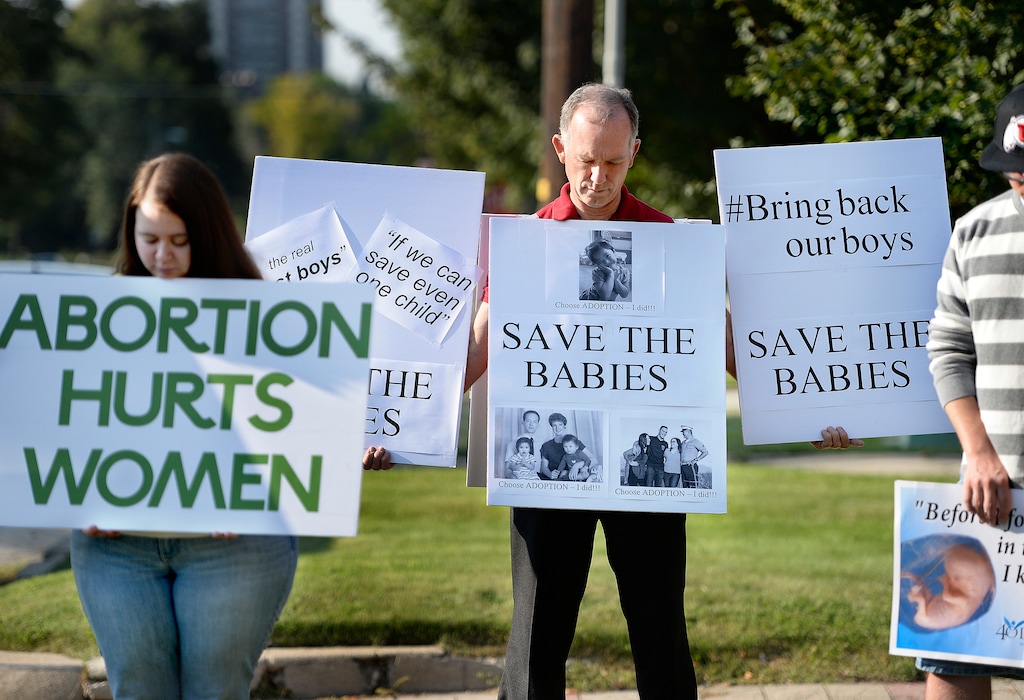 (Scott Sommerdorf | Tribune file photo)
In this 2015 file photo, abortion protesters hold signs as they bow their heads while they listen to Robert Woods read a prayer outside the Salt Lake City Planned Parenthood as part of a nationwide protest, Aug. 22, 2015. A Utah House committee on Wednesday endorsed a proposed ban on abortions after 18 weeks of gestation.
