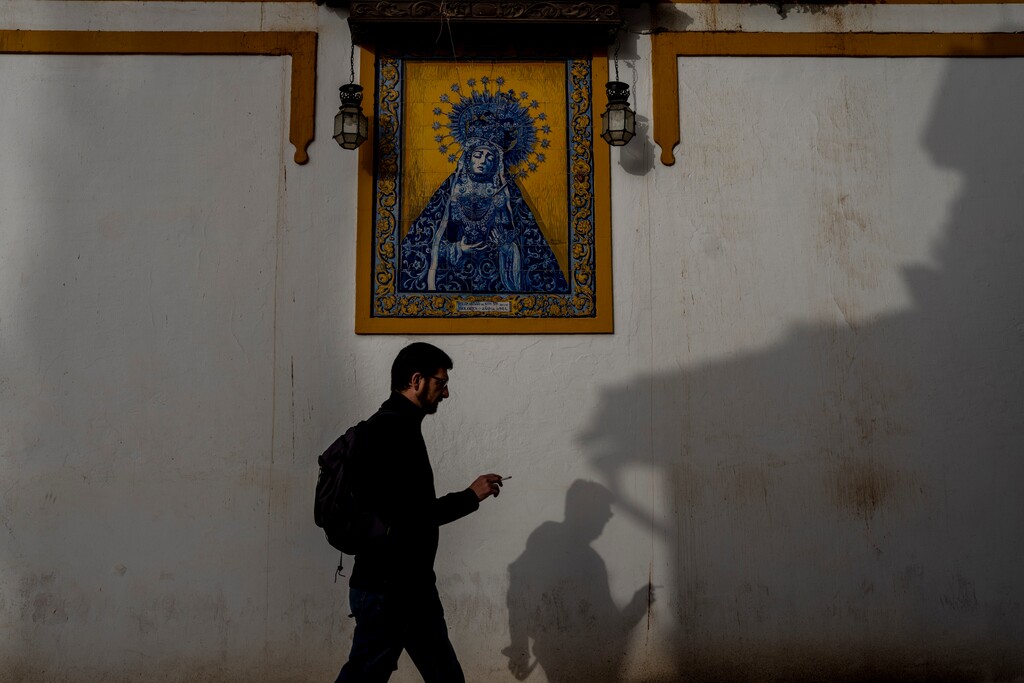 (Manu Fernandez | AP) A man walks in front of a religious image of a Virgin of "Los Dolores" in Cordoba, southern Spain, Sunday, March 27, 2022.