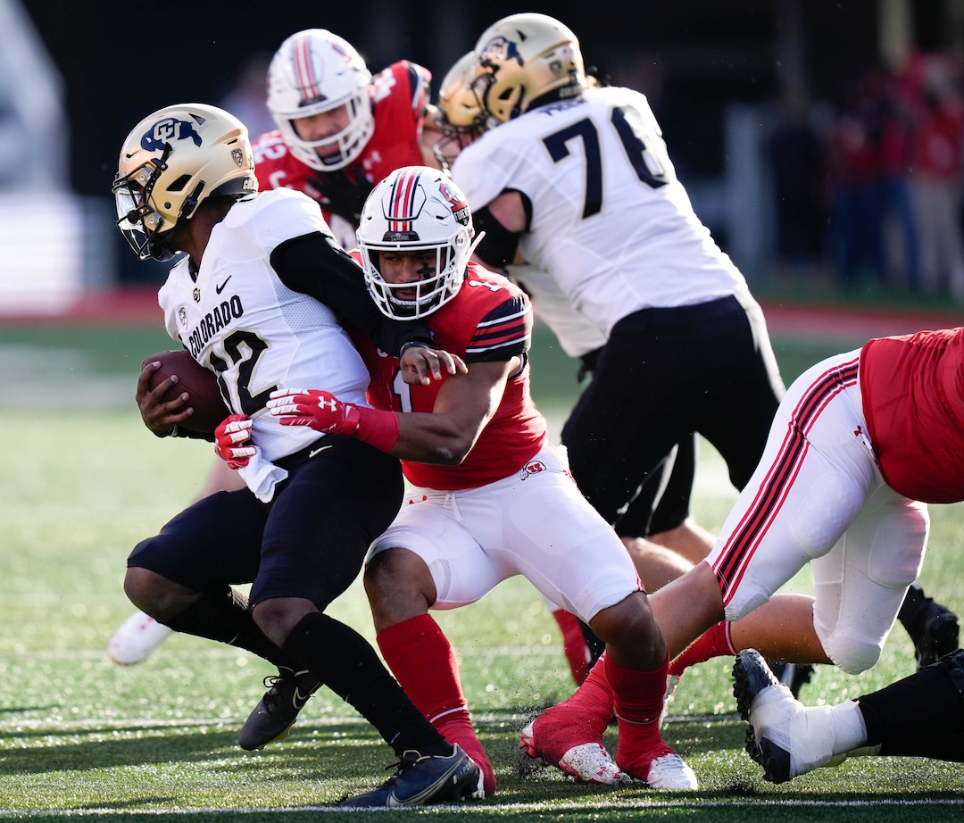 (Francisco Kjolseth | The Salt Lake Tribune) Colorado Buffaloes quarterback Brendon Lewis (12) is taken down by Utah Utes linebacker Nephi Sewell (1) as the University of Utah hosts the Colorado Buffaloes in Pac-12 football, Friday, Nov. 26, 2021 at Rice-Eccles Stadium.