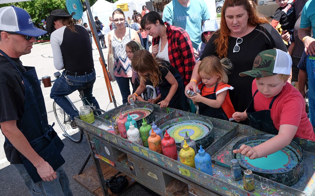 (Francisco Kjolseth  |  The Salt Lake Tribune)  Old spinning records powered by bicycle are turned into unique art by young hands at the "Spin Art" booth at the Ogden Arts Festival that brings local and regional artists, creatives and entertainers to Ogden, UT on June 8th and 9th. The Ogden Arts Festival returned to the historic Union Station located in the heart of downtown.