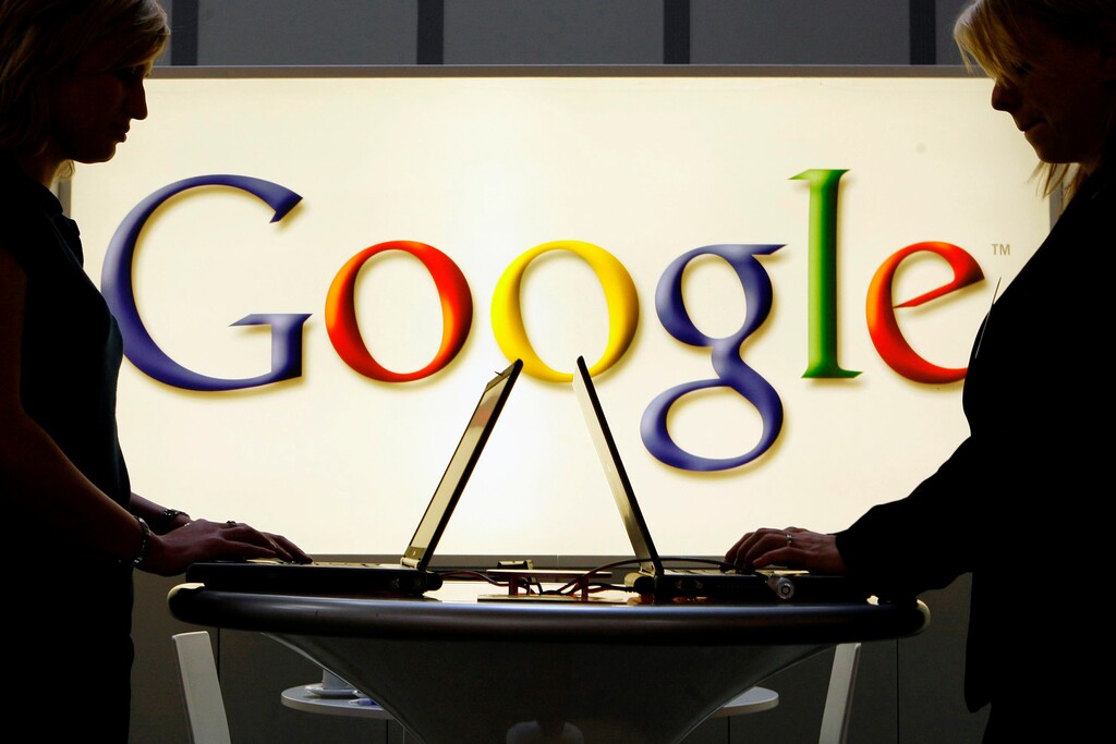 (Jens Meyer | AP file photo)
In this April 17, 2007, photo, exhibitors work on laptop computers in front of an illuminated sign of the Google logo at the industrial fair Hannover Messe in Hanover, Germany. The Justice Department’s lawsuit against Google alleging antitrust violations marks the government’s most significant attempt to protect competition since its groundbreaking case against Microsoft more than 20 years ago.