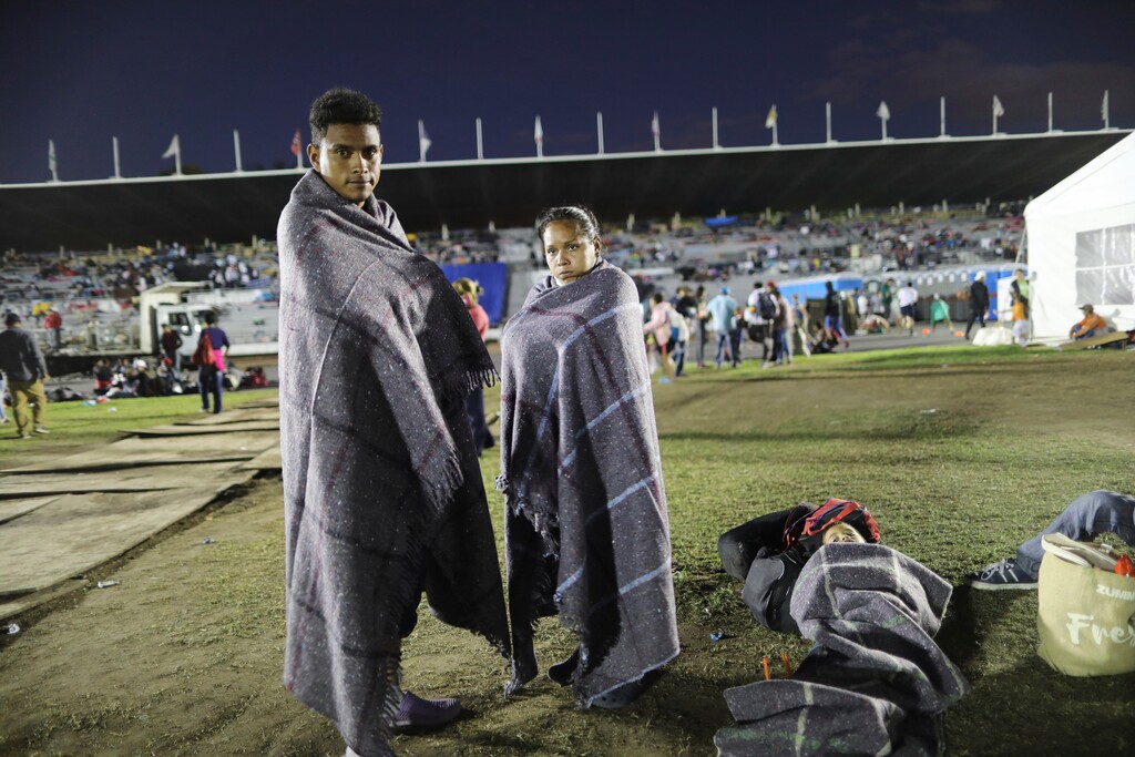 (Rodrigo Abd | AP Photo) Central American migrant Jerson Suazo, left, stands with his wife Anabel Pineda next to their six-year-old son Fernando, at a shelter in the Jesus Martinez stadium, in Mexico City, Monday, Nov. 5, 2018. Thousands of Central American migrants have arrived at the stadium, still hundreds of miles away from their goal of reaching the U.S. a day before midterm elections in which they unwittingly became a central issue.
