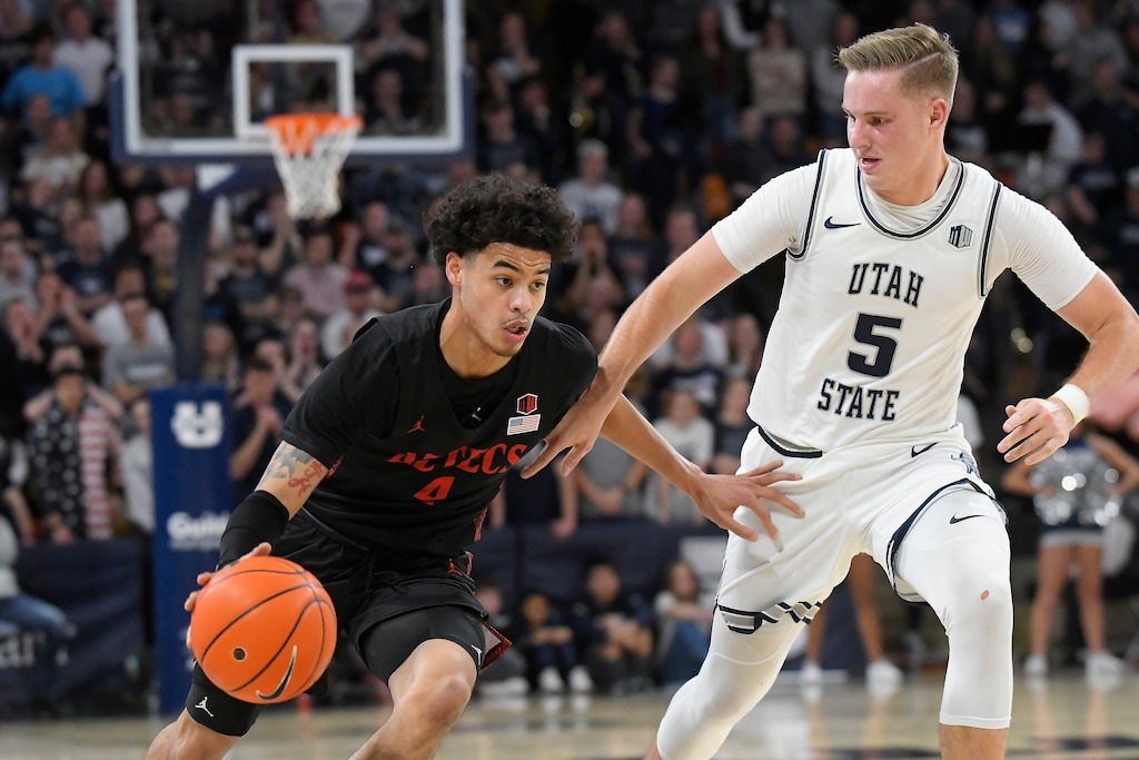 San Diego State guard Trey Pulliam (4) is defended by Utah State guard Sam Merrill during the first half of an NCAA college basketball game Saturday, Jan. 4, 2020, in Logan, Utah. (AP Photo/Eli Lucero)