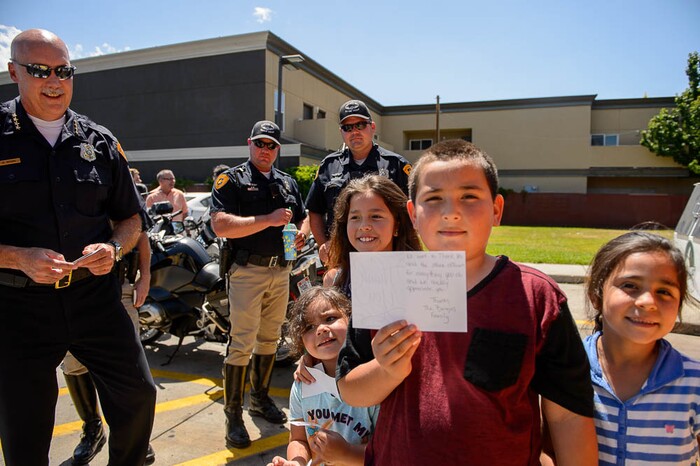 (Trent Nelson | The Salt Lake Tribune)Catalina, Faith, Mario, and Mia Cardenes pose with a thank you note they delivered to Salt Lake City Police Chief Mike Brown (left), Wednesday June 13, 2018, during an event at a Salt Lake City 7-Eleven store promoting the donation of 7,500 Slurpee coupons by the company for police officers to hand out to children.