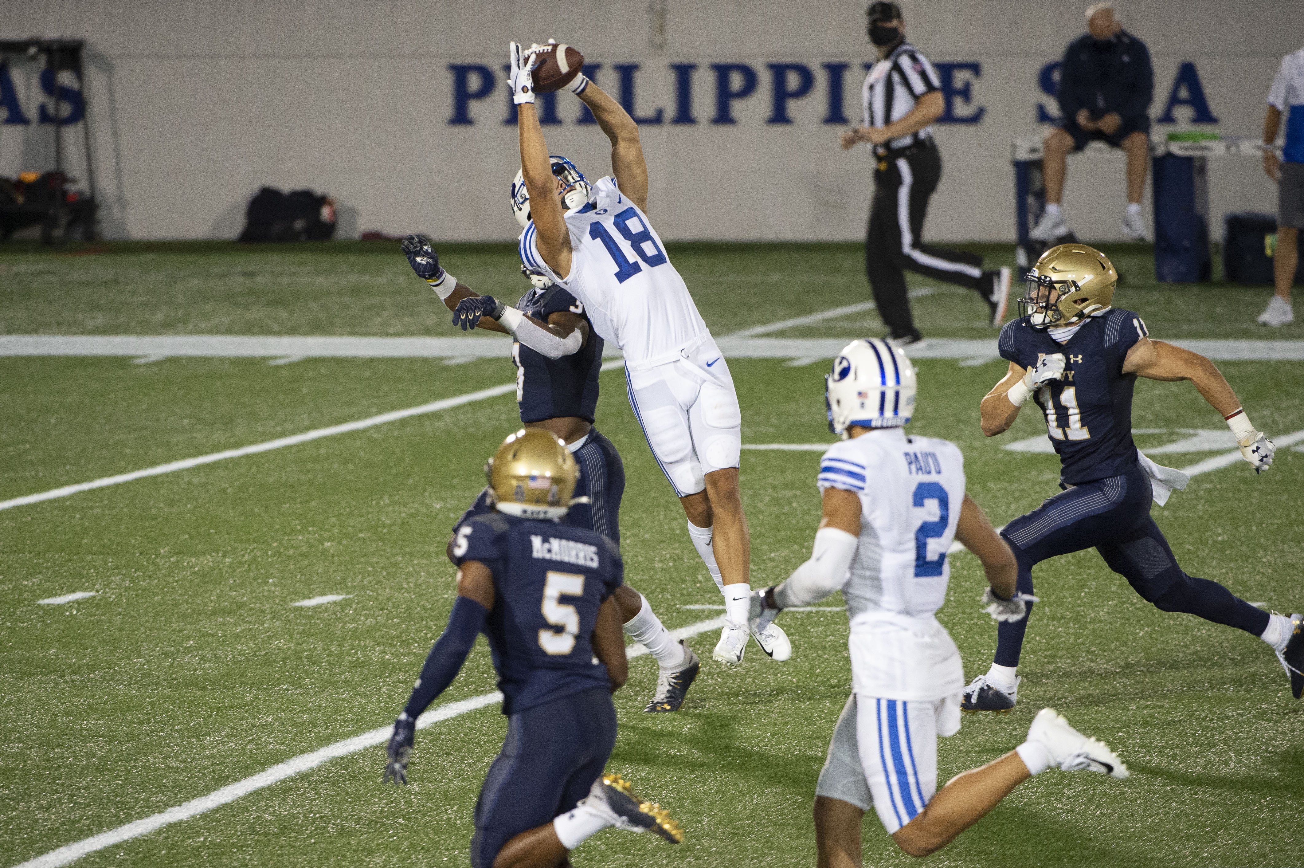 (Tommy Gilligan | AP) BYU wide receiver Gunner Romney (18) leaps to catch a pass over Navy defensive back Cameron Kinley during the second half of an NCAA college football game, Monday, Sept. 7, 2020, in Annapolis, Md.