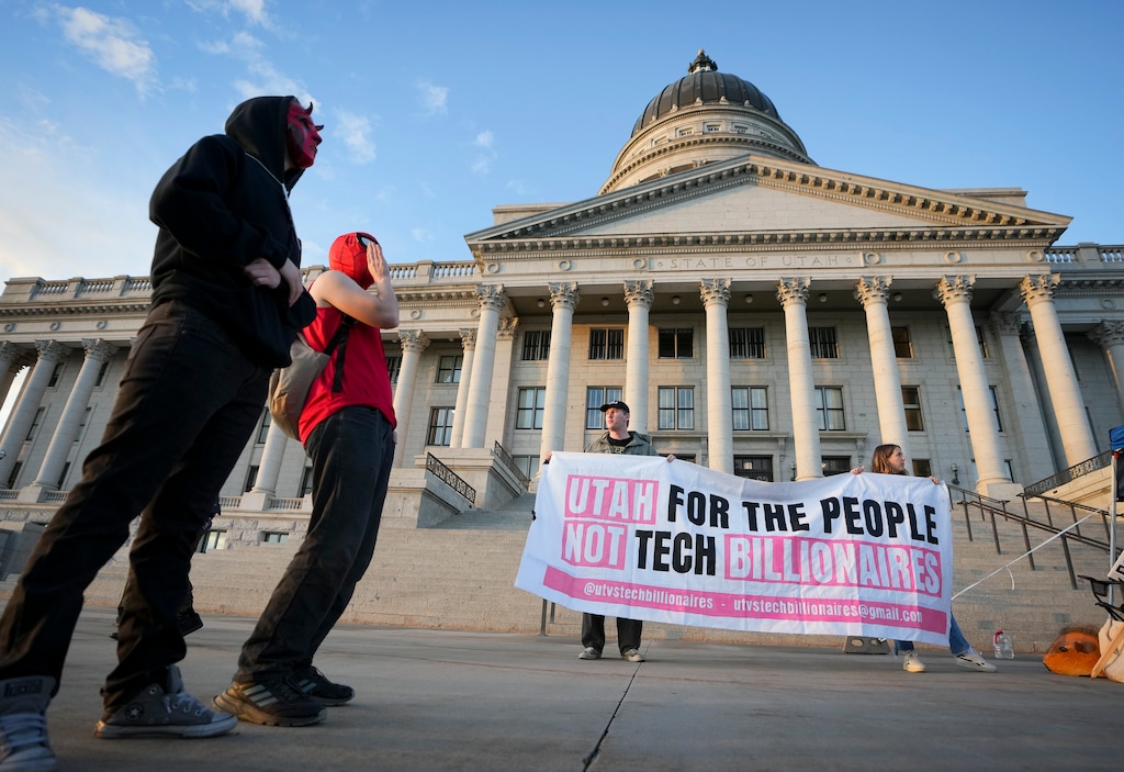 (Bethany Baker | The Salt Lake Tribune) Protesters hold up a sign during a protest in support of Aspen Azalea, a woman arrested and tossed to the ground during a Utah County Planning Commission meeting on data center land use within Utah County, seen in Salt Lake City on Wednesday, Oct. 21, 2026.