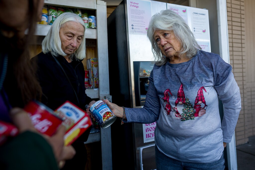 (Trent Nelson | The Salt Lake Tribune) Shar Code and Sandy Shaw organize donations at the Weber Fridge, a community food donation spot in Ogden on Friday, Dec. 12, 2025. Free-to-access fridges offer food without barriers for Utah's hungry.