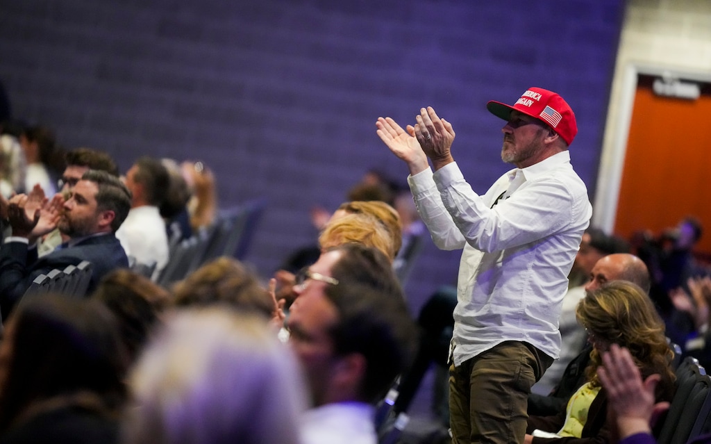 (Bethany Baker  |  The Salt Lake Tribune) A man claps as people watch the memorial services for Charlie Kirk during an event at the Utah Valley Convention Center in Provo on Sunday, Sept. 21, 2025.