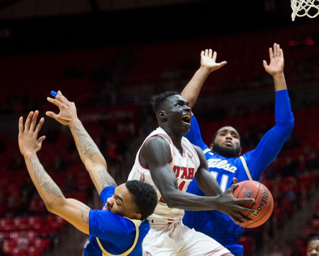(Rick Egan  |  The Salt Lake Tribune)        Utah Utes forward Both Gach (11) splits his defenders, Tulsa Golden Hurricane guard DaQuan Jeffries (2) and Tulsa Golden Hurricane forward Jeriah Horne (41), in basketball action between, Utah Utes and Tulsa Golden Hurricane, at the Jon M. Huntsman Center, Saturday, Dec. 1, 2018.
