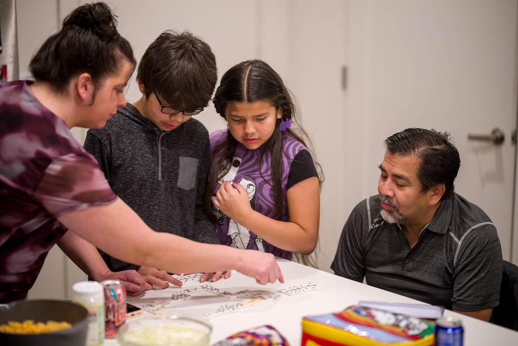 (Trent Nelson | The Salt Lake Tribune) Tammy Staples y Gildardo Escobar jugando al dominó con sus hijos Wenceslao y Jessica en West Valley City el domingo 7 de diciembre de 2025.