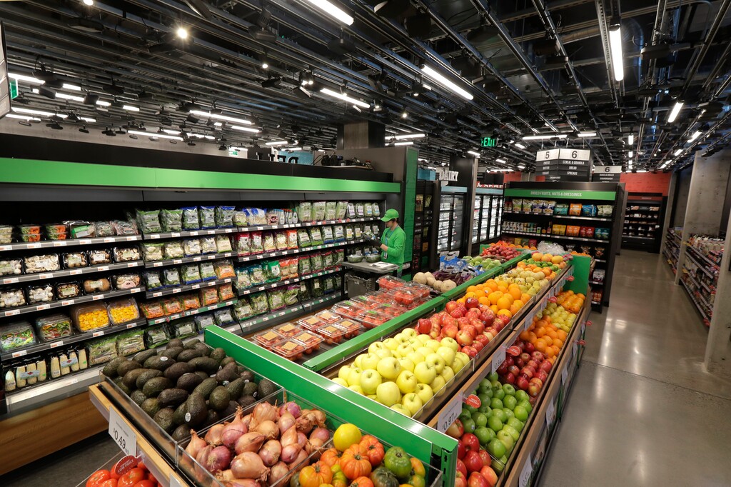 (Ted S. Warren | Associated Press) In this Feb. 21, 2020 photo, a worker checks items on a shelf in the produce section of a grocery store.