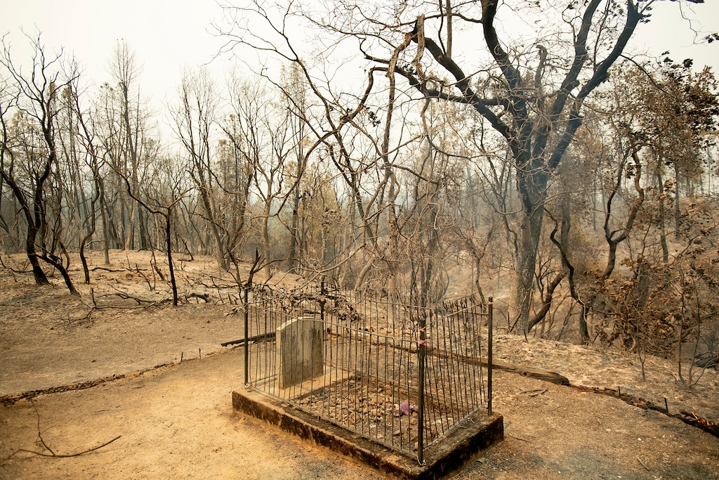 (AP Photo/Noah Berger) The historic Pioneer Baby's Grave rests among trees scorched by the Carr Fire in Shasta, Calif., on Friday, July 27, 2018. The fire rapidly expanded Thursday when erratic flames swept through the historic Gold Rush town of Shasta and nearby Keswick, then cast the Sacramento River in an orange glow as they jumped the banks into Redding.