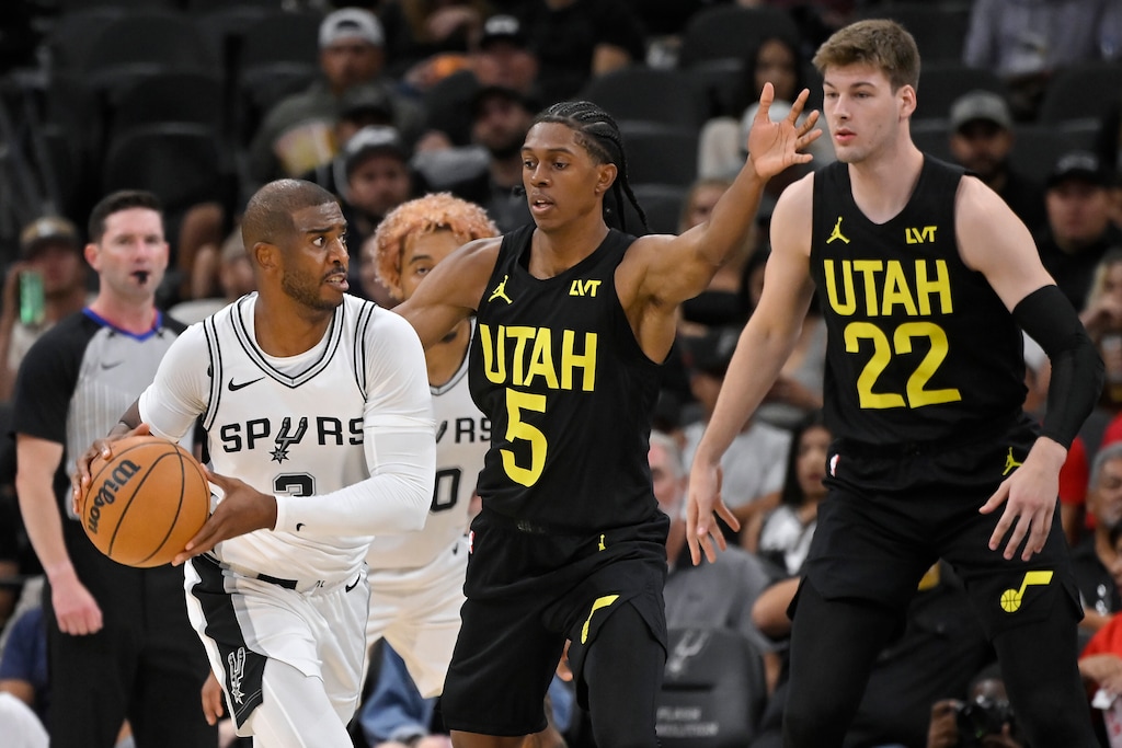 San Antonio Spurs guard Chris Paul (3) drives against Utah Jazz's Cody Williams (5) and Kyle Filipowski during the second half of an NBA basketball game, Saturday, Oct. 12, 2024, in San Antonio. San Antonio won 126-120. (AP Photo/Darren Abate)