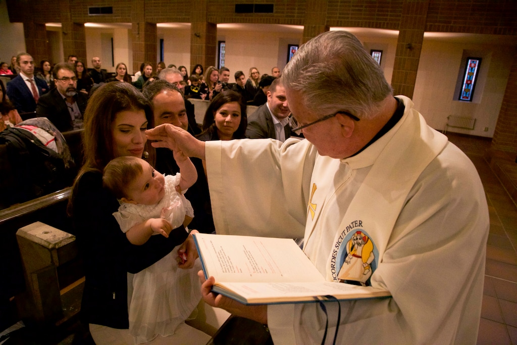 (Vitnija Saldava | AP) Vicar Fulvio Cesare leads a baptism ceremony at a Catholic Cathedral in downtown Stockholm in 2016.