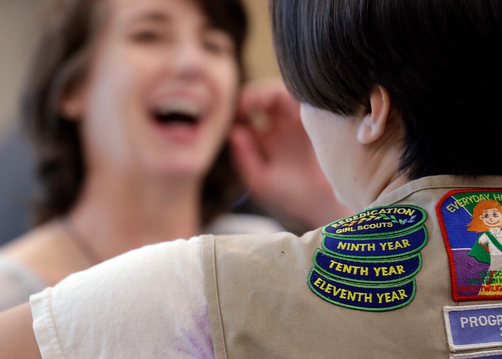 (Elaine Thompson | The Associated Press) Girl Scouts of Western Washington CEO Megan Ferland, left, talks with a Girl Scout at a demonstration of some of their activities in Seattle on June 18, 2018. 