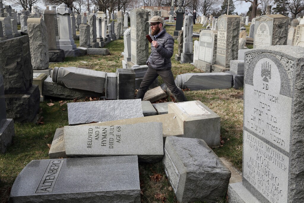 (Jacqueline Larma | The Associated Press file photo) In this Feb. 27, 2017, photo, Rabbi Joshua Bolton of the University of Pennsylvania's Hillel center surveys damaged headstones at Mount Carmel Cemetery in Philadelphia. The shooting rampage that killed more than 10 people at Pittsburgh's Tree of Life Synagogue on Saturday, Oct. 27, 2018, is being decried as the deadliest attack on Jews in U.S. history. Yet the carnage, however unprecedented, is not an aberration: Year after year, decade after decade, anti-Semitism proves to be among the most entrenched and pervasive forms of hatred and bigotry in the United States.