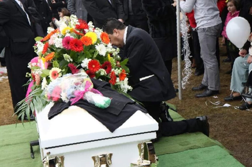 (Photo courtesy of Utah Department of Transportation) Martin Herrera mourns at the casket of his daughter, Maria, who was killed in a car crash caused by speeding.