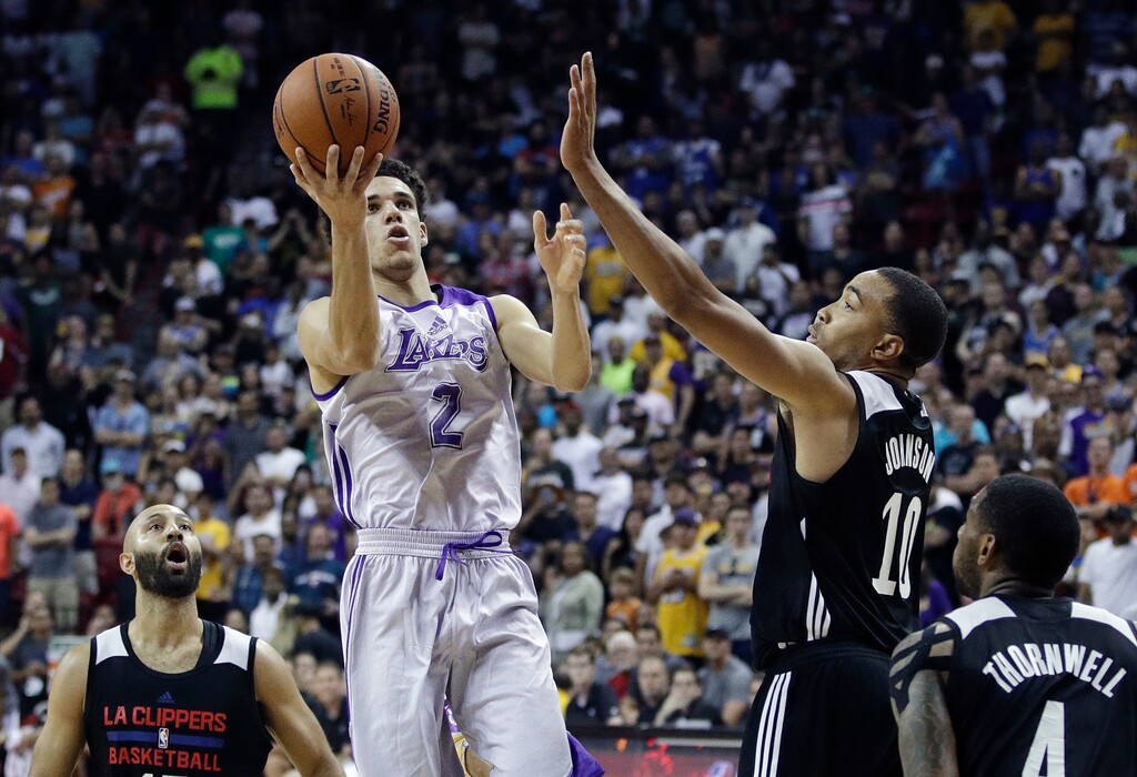 FILE - In this July 7, 2017 file photo, Los Angeles Lakers' Lonzo Ball shoots over Los Angeles Clippers' Brice Johnson (10) during overtime of an NBA summer league basketball game, in Las Vegas. Ball's dud of a debut is long forgotten. And on Wednesday night, July 12 so were his Big Baller Brand sneakers. Now he has the best game of the NBA Summer League — and another playoff game for a chance to top it. Ball had 36 points, 11 assists, eight rebounds and five steals to lead the Los Angeles Lakers to a 103-102 victory over the Philadelphia 76ers in their opening game of the tournament stage. (AP Photo/John Locher, File)