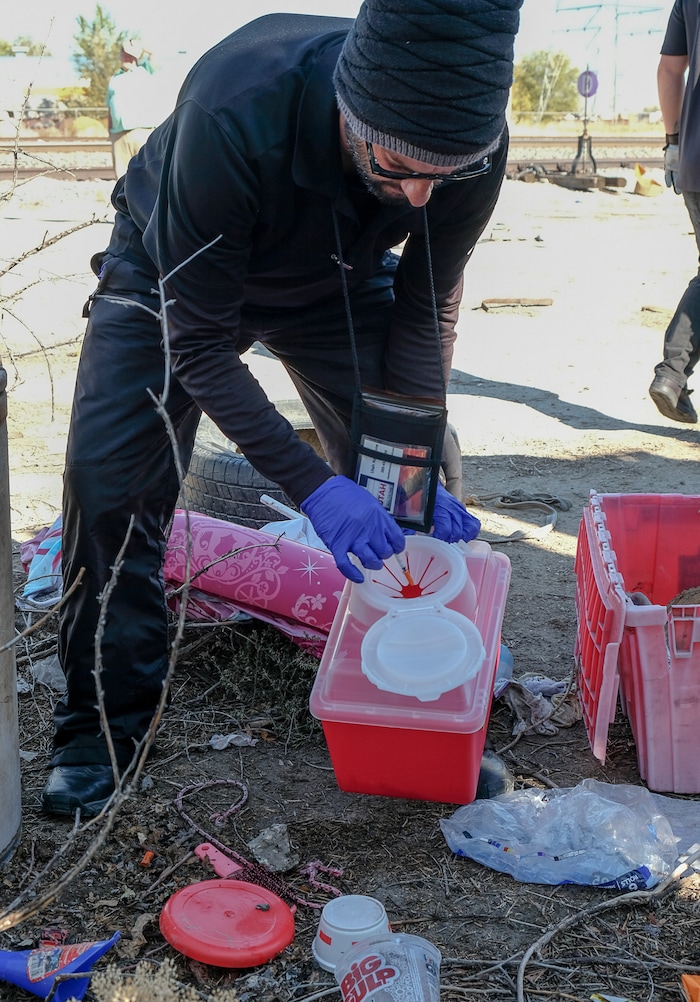 (Francisco Kjolseth  |  The Salt Lake Tribune)  Patrick Rezac, Executive Director of One Voice Recovery, removes a needle left behind at a former transient camp in West Salt Lake recently. In an effort to curb the incidents of hepatitis C HIV and STD's, the grass roots team hands out disease prevention kits and provides a needle exchange program.