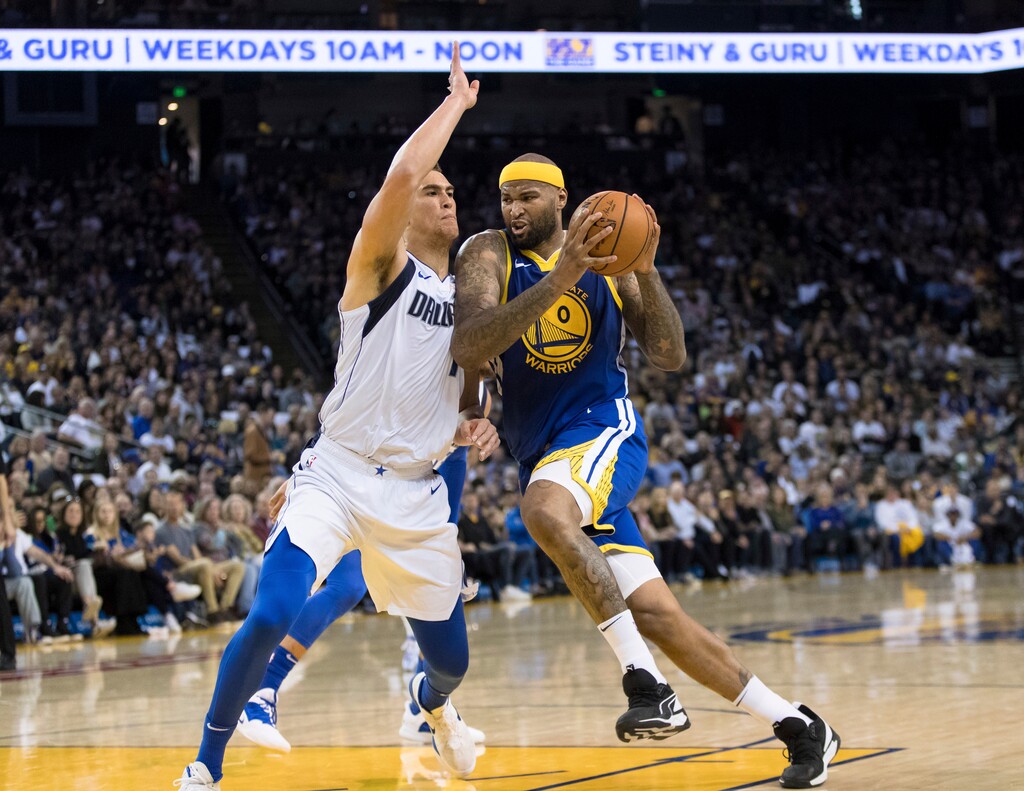 Golden State Warriors center DeMarcus Cousins, right, collides with Dallas Mavericks forward Dwight Powell in the second half of an NBA basketball game Saturday, March 23, 2019 in Oakland, Calif. (AP Photo/John Hefti)