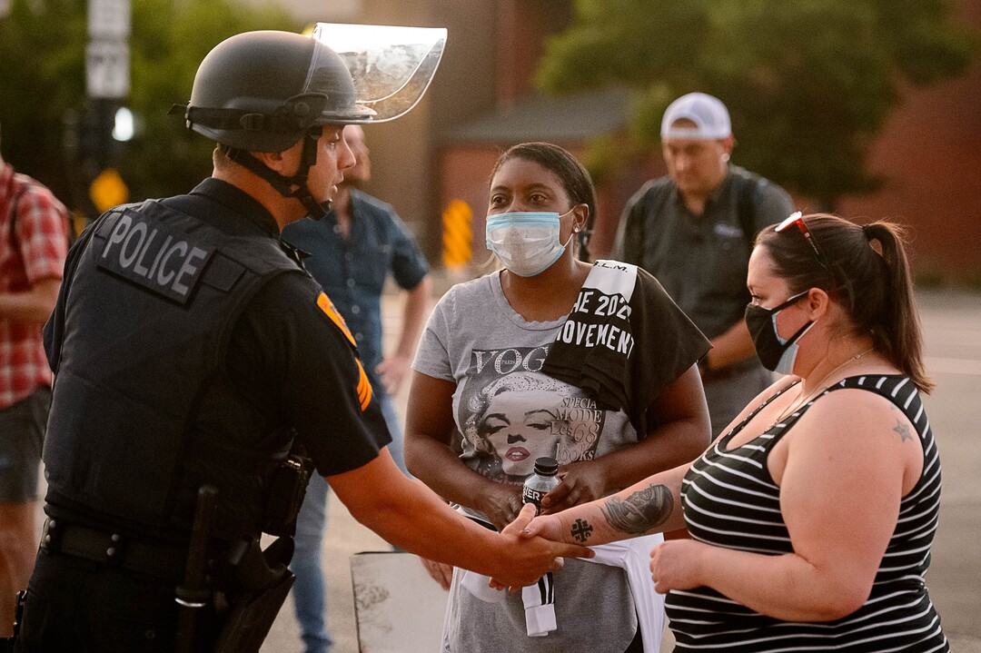 (Trent Nelson  |  The Salt Lake Tribune) A police officer shakes hands with protesters marching in Salt Lake City on Tuesday, June 2, 2020.