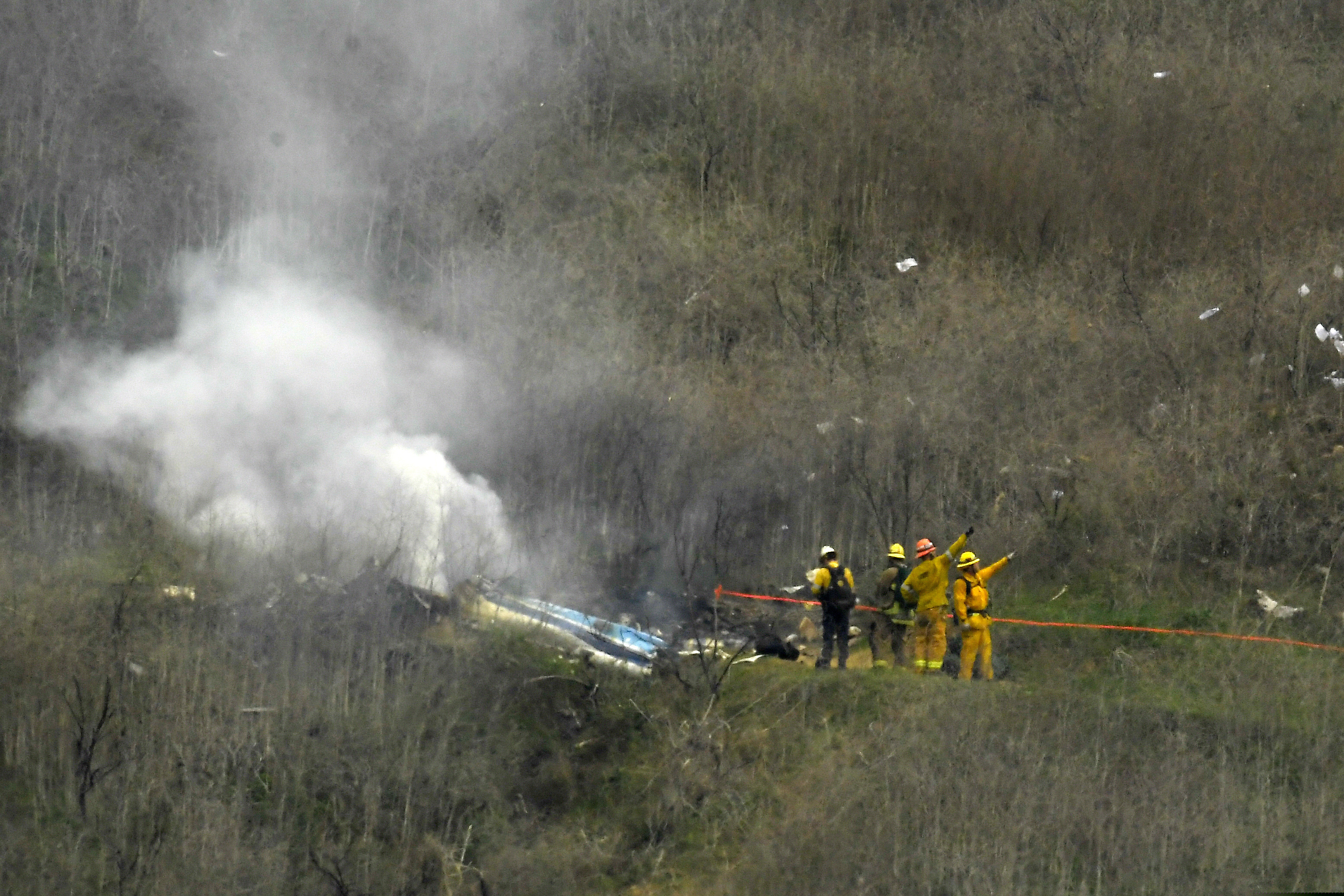 (AP Photo | Mark J. Terrill) In this Jan. 26, 2020 photo firefighters work the scene of a helicopter crash where former NBA star Kobe Bryant died, in Calabasas, Calif. Federal investigators say wreckage from the helicopter that crashed last month and killed Bryant, his daughter and seven others did not show any outward evidence of engine failure, the National Transportation Safety Board said Friday, Feb. 7, 2020.